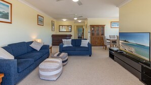 A living room with two sofas, a television, and a cabinet. - Braemar 7 - Lakefront apartment (Forster)