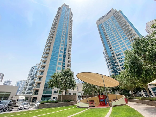 A high-rise residential building with a modern design, featuring balconies and large windows.