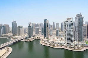 A high-rise urban area with modern architecture, a waterfront promenade, and a bridge connecting different parts of the city.