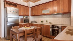 A kitchen with wooden cabinets, a stainless steel refrigerator, a microwave, and a stove.