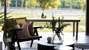 Un salon moderne avec un canapé, une table basse et une vue sur un jardin.