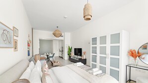 Une chambre d’hôtel moderne dotée d’un grand lit, d’un bureau, d’une télévision et d’un coin salon offrant une vue sur la ville.