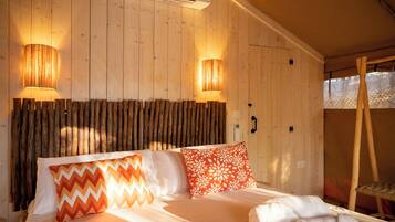 Quarto de madeira com uma cama, duas luminárias na parede e cabeceira de madeira.