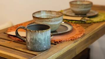 A wooden table with ceramic bowls and a mug.
