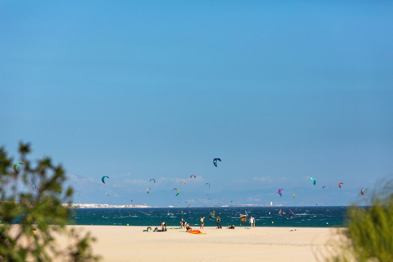 Una playa con gente y cometas.