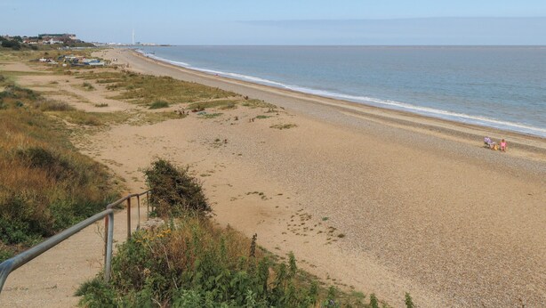 A beach with a clear view of the ocean, a sandy path, and a distant lighthouse. - Sole Bay Cottage (Lowestoft)