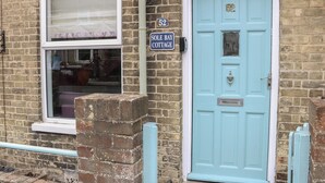 A light blue door with a number plate reading "52" and a sign above it stating "SOLE BAY COTTAGE." - Sole Bay Cottage (Lowestoft)