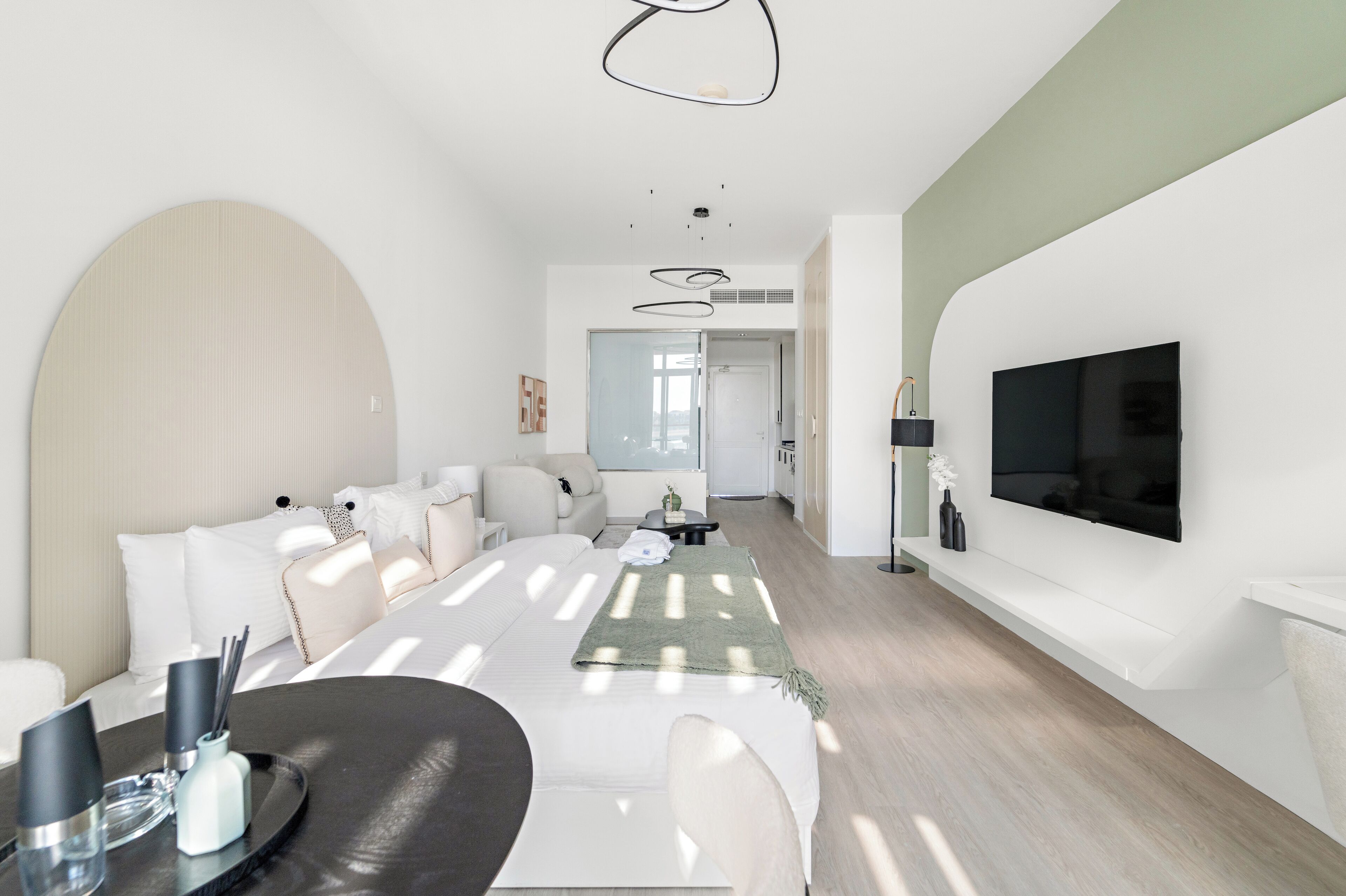 Una sala de estar moderna con un sofá, una mesa de centro y un televisor de pantalla plana montado en la pared.