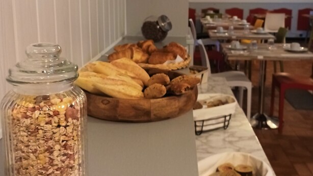 A breakfast buffet with various pastries and a jar of granola. - Hôtel Le Cheval Blanc (Saint-Maixent-l'Ecole)