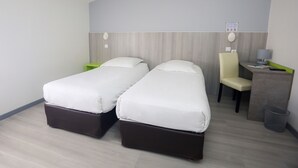 A hotel room with two single beds, a desk with a chair, a trash bin, and a wall-mounted phone. - Hôtel Le Cheval Blanc (Saint-Maixent-l'Ecole)