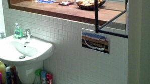 Ein Badezimmer mit Waschbecken, Spiegel und Pflegeprodukten.