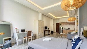 A modern hotel room with a bed, desk, chair, wardrobe, and kitchenette. - HOLO BEN THANH SAIGON SERVICED HOMESTAY (Ho Chi Minh City)