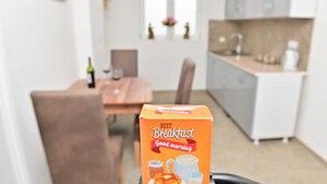 A breakfast box labeled "Best Breakfast Good morning" in a modern kitchen with a dining table and chairs.