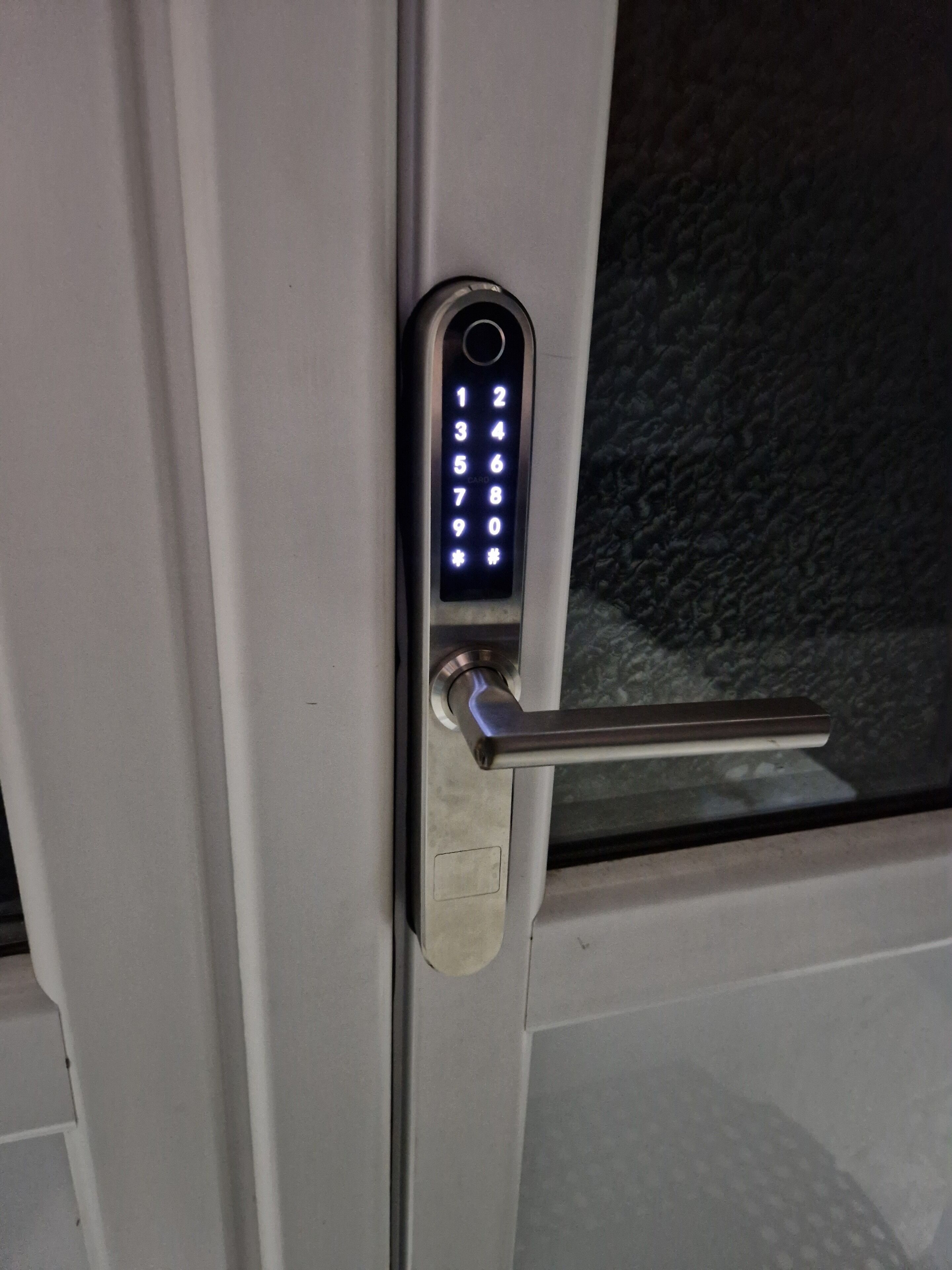 A door with a numeric keypad lock and a metallic handle.