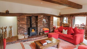 A cozy living room with a brick fireplace, a red sofa, and a wooden coffee table.