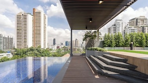 A rooftop pool with a view of high-rise buildings and a covered walkway.