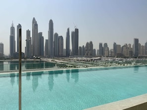 Relax by the infinity pool overlooking the city skyline.