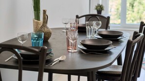 A dining table set with plates, bowls, glasses, and cutlery.