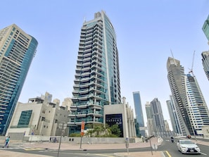 Ein modernes Hochhaus mit einer geschwungenen Fassade, umgeben von weiteren hohen Gebäuden.