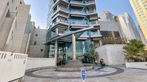 Ein hohes, modernes Gebäude mit einem markanten, winkelförmigen Design, das mehrere Balkone und eine Glasfassade aufweist.