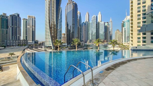 Ein moderner Poolbereich mit freiem Blick auf hohe Gebäude im Hintergrund.