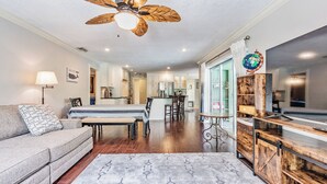 A spacious living area with a sofa, a dining table, and a kitchen in the background.