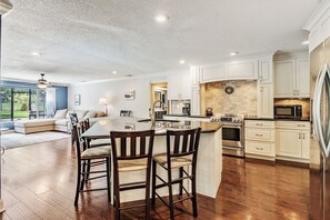 Une cuisine spacieuse avec un îlot central, des chaises en bois et une table à manger.