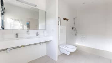 Un bagno moderno con lavandino, specchio e water bianchi.