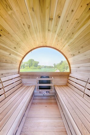 Una sauna con bancos de madera y un banco con sillón de masaje.