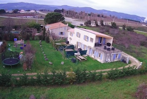 A two-story house with a fenced backyard, a trampoline, and a small pool.