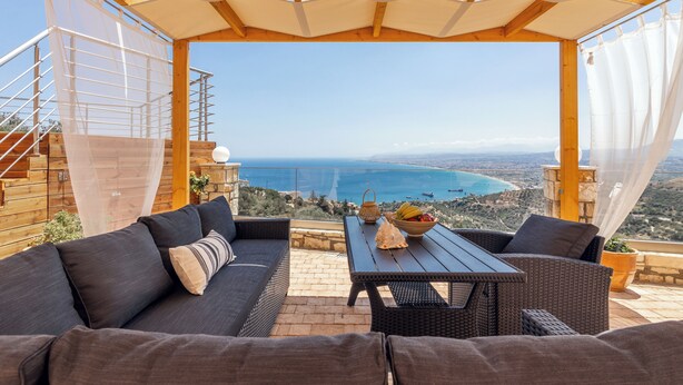 A terrace with a view of the sea, furnished with a sofa, table, and chairs. - Nami Villa SeaView | Private Pool  (Heraklion)