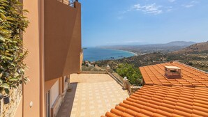 A building with a tiled roof and a view of the sea. - Nami Villa SeaView | Private Pool  (Heraklion)