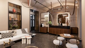 A modern hotel lobby with a sofa, coffee table, and seating area. - Hotel GIN Budapest (Budapest)
