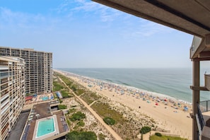 Hotel alto com piscina e vista para a praia.
