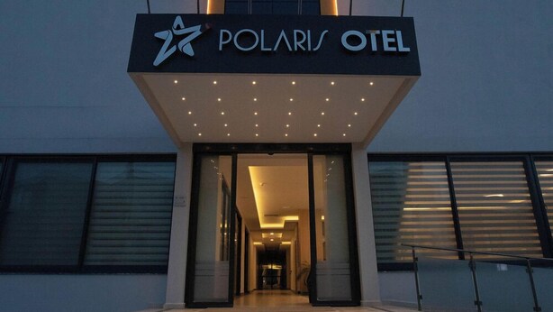 Exterior do Hotel Polaris com design moderno, destacando uma entrada imponente com degraus que levam à porta.