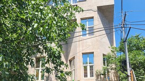 A hotel with outdoor seating, a sign indicating "Hotel Rent A Car," and a building with a sign that reads "OLKAY." - Olive Hotel (Yerevan)