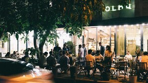 An outdoor seating area of a restaurant with patrons dining. - Olive Hotel (Yerevan)