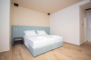 A bedroom with a bed, bedside tables, and a light blue headboard.