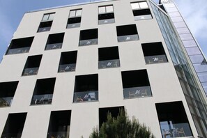 A multi-story building with a modern architectural design, featuring a series of rectangular windows and a glass facade on one side. - Hotel Alion21 (Durrës)