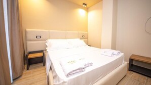 A hotel room with a bed, bedside tables, and a wall-mounted light. - Hotel Alion21 (Durrës)