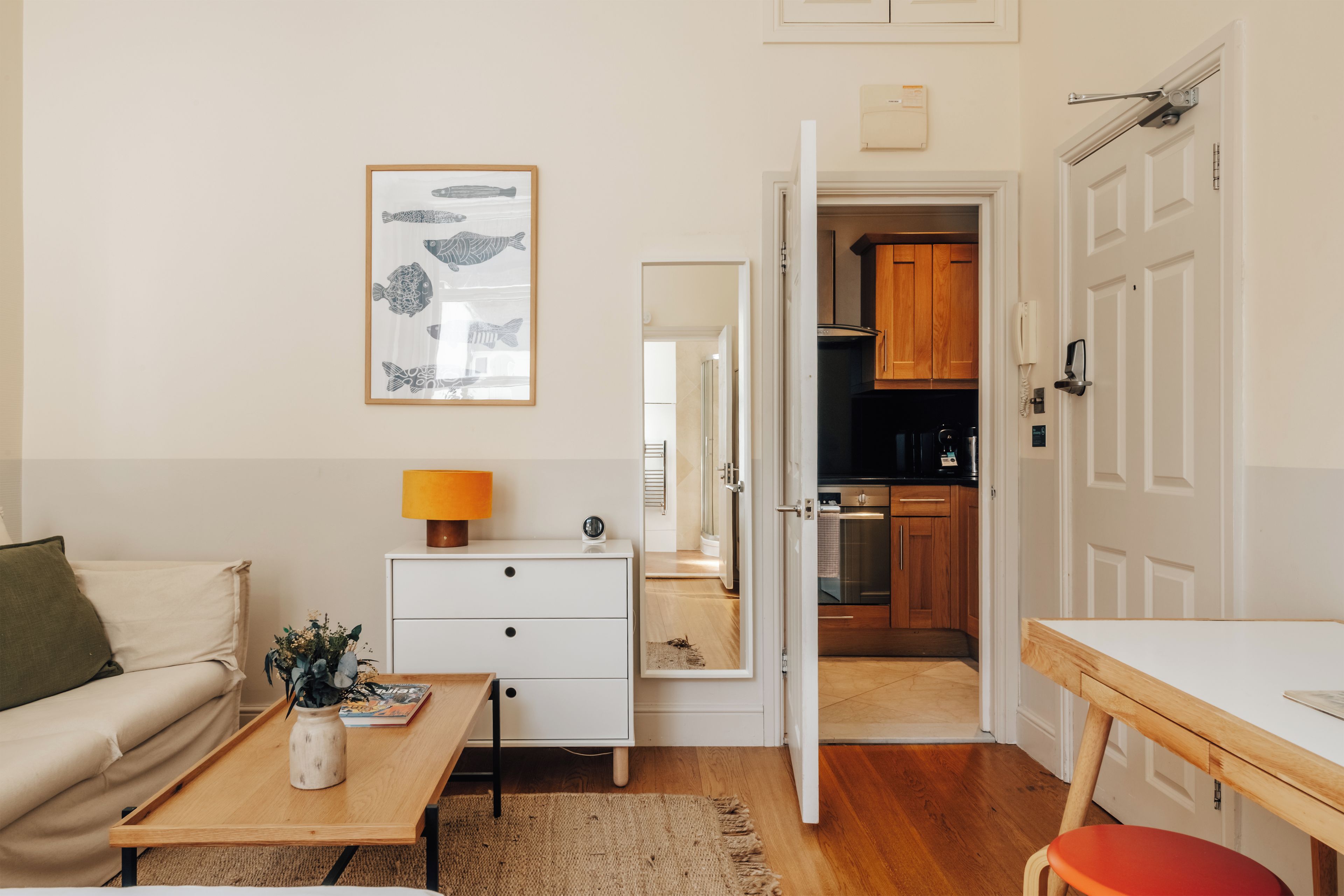 Un espacio habitable funcional con kitchenette, comedor y sofá.