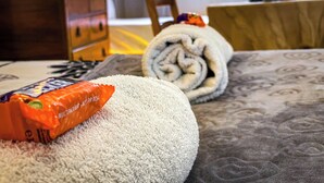 A bed with a rolled-up towel and a chocolate bar on it. - Lovely Flat Near Train Station and Central London (London)