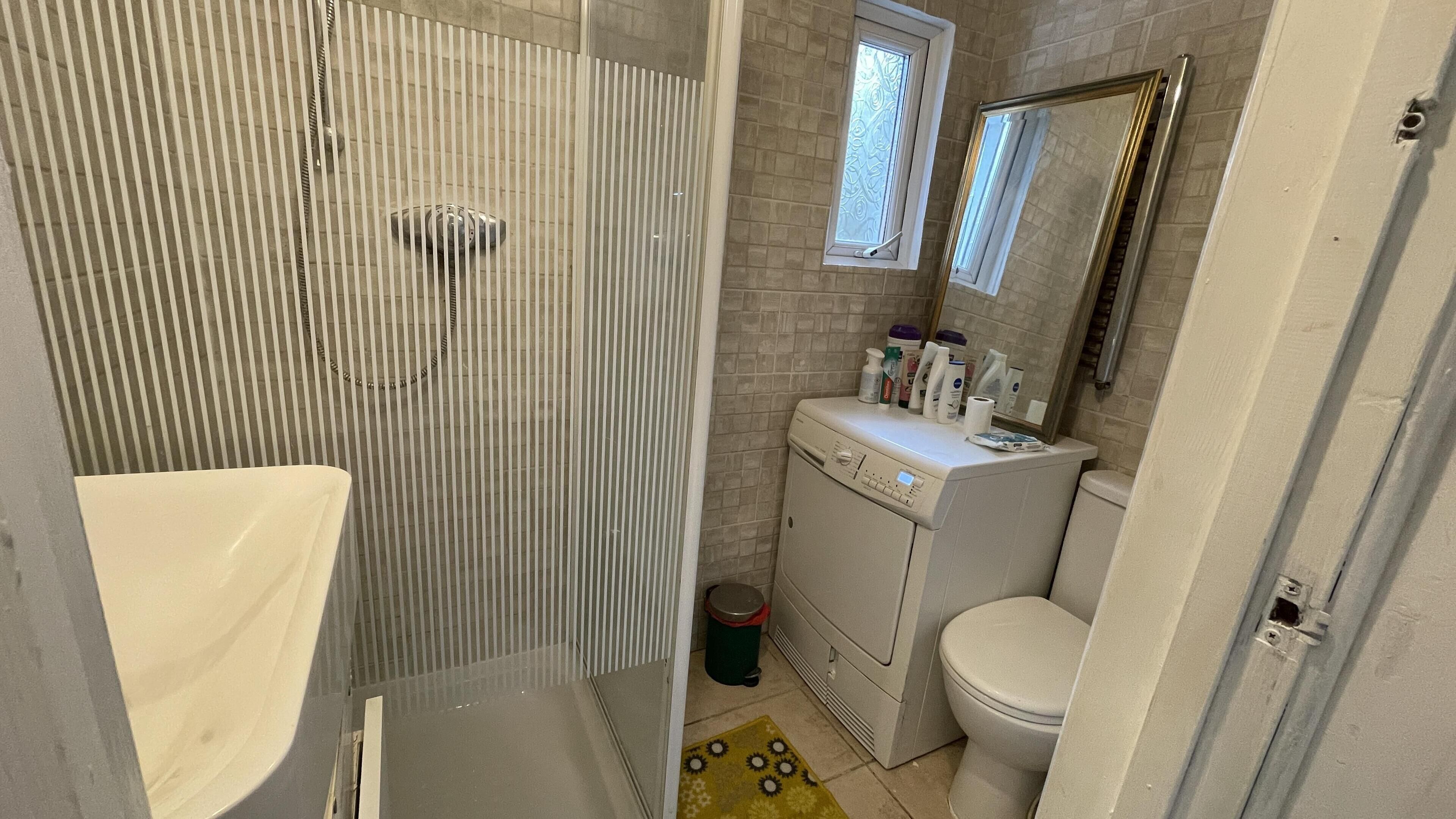 Ein kleines Badezimmer mit Dusche, Toilette und Waschbecken.