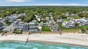 An aerial view of a coastal residential area with houses, a beach, and ocean waves. - Welcome To Tidal Fix! Classic Sea Side Cottage With Modern Comforts RPAM094 (Harwich)