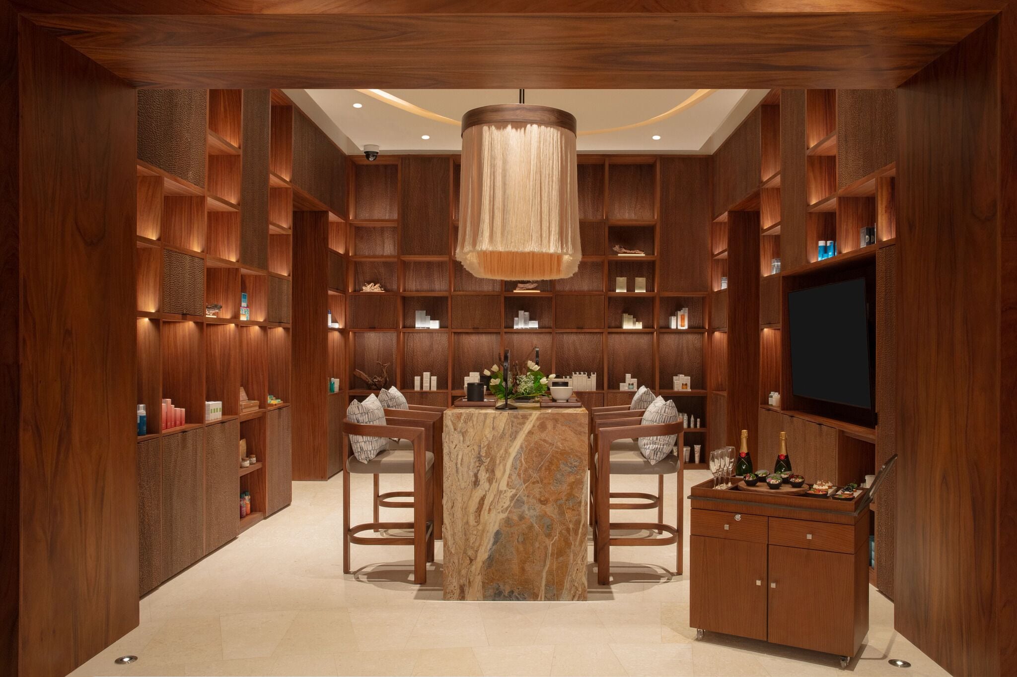 A modern interior with a marble-topped table, wooden shelving, and a television.
