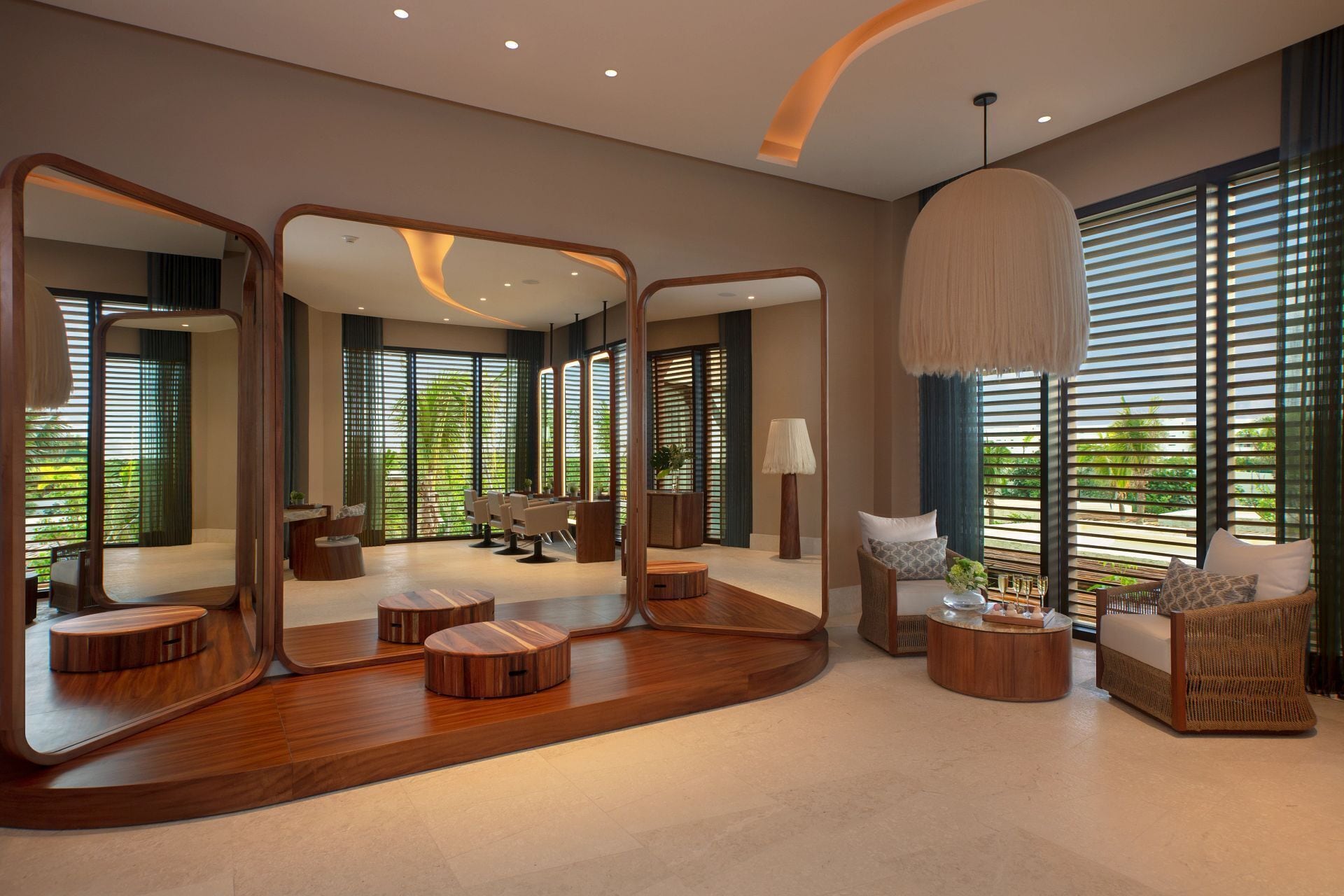 A spacious room with a large mirror, wooden furniture, and a view of greenery outside.