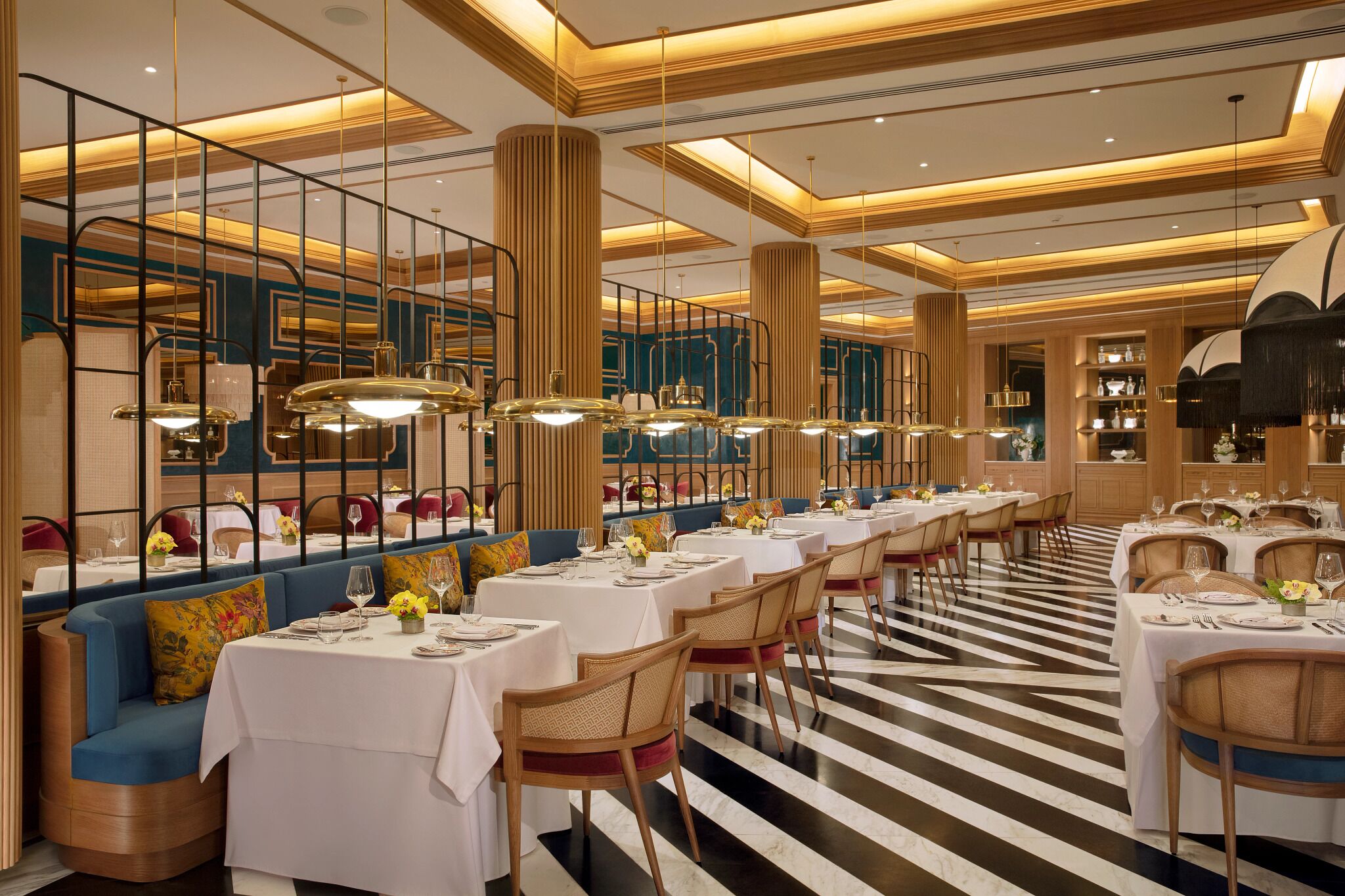 Ein Restaurant mit langen Tischen, Stühlen und einem Streifenboden.