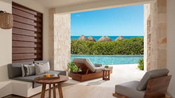 Un salón moderno con vistas a una piscina y al océano.