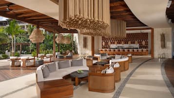 A spacious outdoor lounge area with a variety of seating options, including sofas and chairs, and a bar area with a well-stocked selection of beverages.