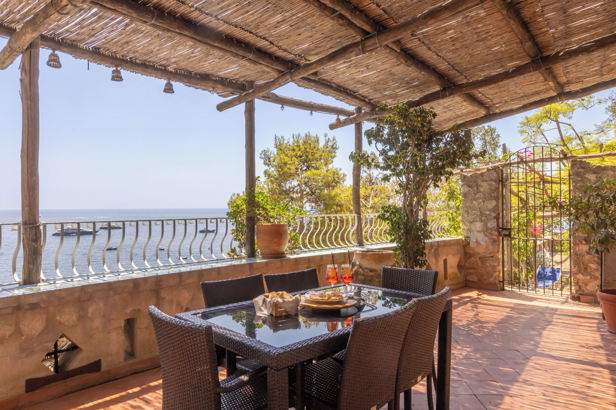 Eine Terrassenanlage im Freien mit Tisch und Stühlen, mit Blick auf ein Gewässer.